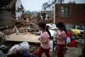 Children picking up their belongings from their home after it was ravaged by a tornado. - Sakshi Post