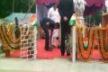 The video grab showing the  PSO strapping the minister’s sandals. - Sakshi Post