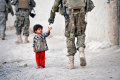 A US soldier gestures to a Afghan toddler during combing operations. (Representational Image) - Sakshi Post