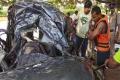 The rescue team clearing the mangled remains of the ill-fated car that was plunged into a canal at Thallapalem village of Nidadavolu mandal on Sunday. - Sakshi Post