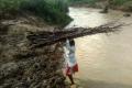 Naikpod woman crossing river with a load of firewood on her head - Sakshi Post