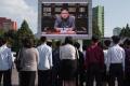 North Koreans listen to their leader Kim Jong-Un speaking on TV  outside the central railway station in Pyongyang - Sakshi Post