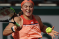 Jelena Ostapenko returns the ball to Ukraines Kateryna Kozlova during their first round match of French Open Jelena Ostapenko returns the ball to Ukraines Kateryna Kozlova during their first round match of French Open - Sakshi Post