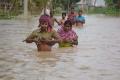 Indian villagers wade along a flooded street after heavy downpour in Baldakhal village, Agartala. - Sakshi Post