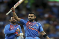 Virat Kohli waves his bat to the crowd as he celebrates his teams six wicket win over Australia in their Twenty20 cricket match in Sydney - Sakshi Post