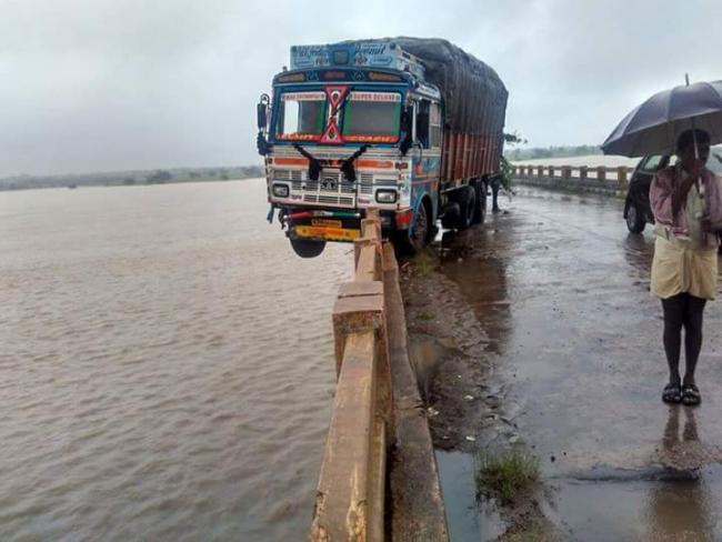 Both driver and his assistant were forced to stay put inside the cabin all the night as they feared of the truck falling down into the river - Sakshi Post