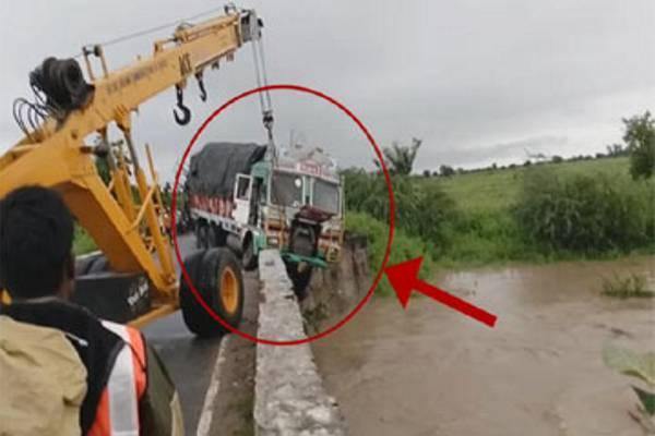 The speeding lorry lost control and hung perilously off the bridge on national highway in Nizamabad district Saturday morning. - Sakshi Post