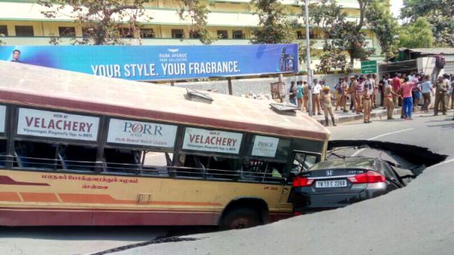 A city bus and a car at the site of the cave-in on Anna Salai road. - Sakshi Post