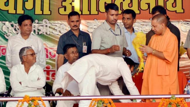 MLA Amanmani Tripathi  touching the feet of Chief Minister Yogi Adityanath at a public meeting on Saturday. - Sakshi Post