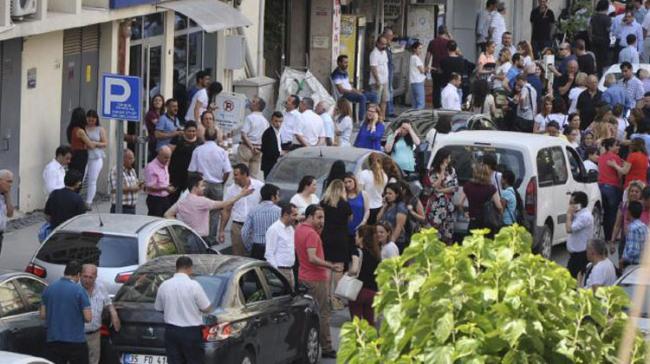 People gather outside an office building following an earthquake in the coastal city of Izmir, Turkey. Picture: Mehmet Ozdogru/Depo Photos via AP Source:AP - Sakshi Post