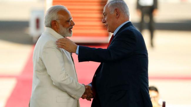 Israeli Prime Minister Benjamin Netanyahu (R) greets his Indian counterpart Narendra Modi (L) at Ben Gurion airport near Tel Aviv on July 4, 2017 (AFP Photo/Jack GUEZ) - Sakshi Post