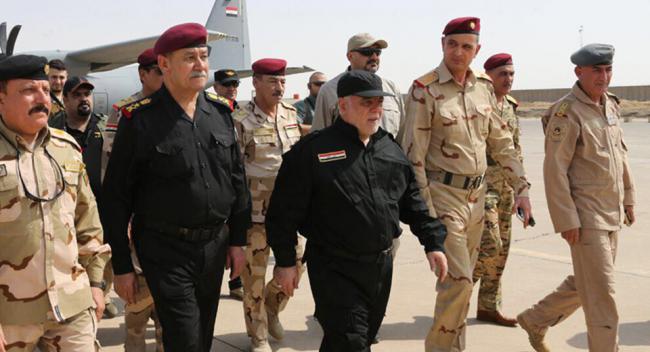 Iraqi Prime Minister Haider al-Abadi (black military uniform and black cap) arrives in  Mosul to announce the recapture of the city. - Sakshi Post