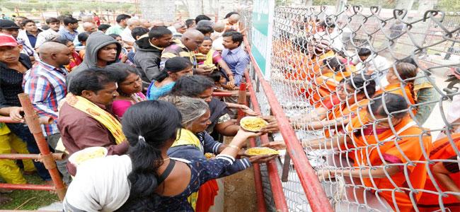 Volunteers distributing prasadam to devotees in the queue lines in Tirumala. Volunteers distributing prasadam to devotees in the queue lines in Tirumala. - Sakshi Post