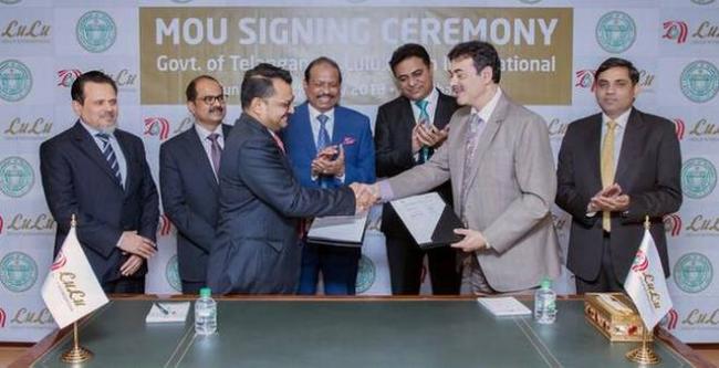 Industries department principal secretary Jayesh Ranjan (right) shaking hands with a LuLu Group official at the MoU signing ceremony in the presence of Telangana IT Minister KT Rama Rao. - Sakshi Post