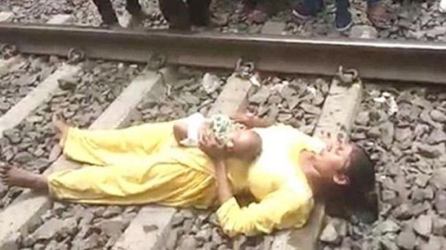 A woman, and her two-month old child, had a miraculous escape after she lay down between the tracks A woman, and her two-month old child, had a miraculous escape after she lay down between the tracks - Sakshi Post