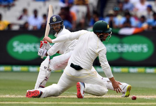 Australia’s Aaron Finch dives to field the ball hit by India’s batsman Mayank Agarwal (L) during day three of the third cricket Test match between Australia and India in Melbourne on December 28, 2018. - Sakshi Post