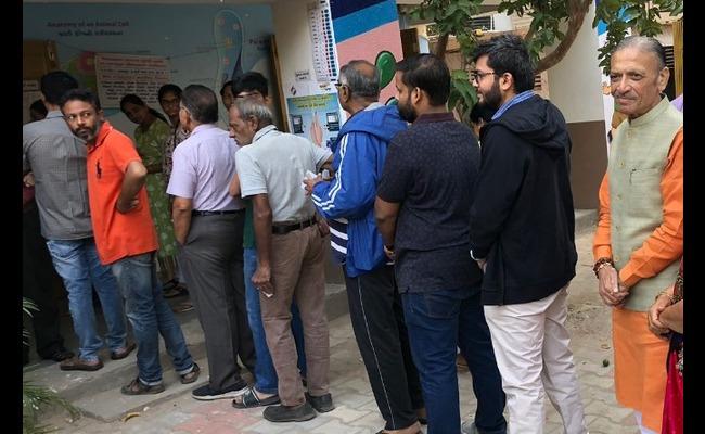 Voters wait in a queue outside a polling station in Gujarat on Monday (Source: @DeshGujarat via Twitter) Voters wait in a queue outside a polling station in Gujarat on Monday (Source: @DeshGujarat via Twitter) - Sakshi Post